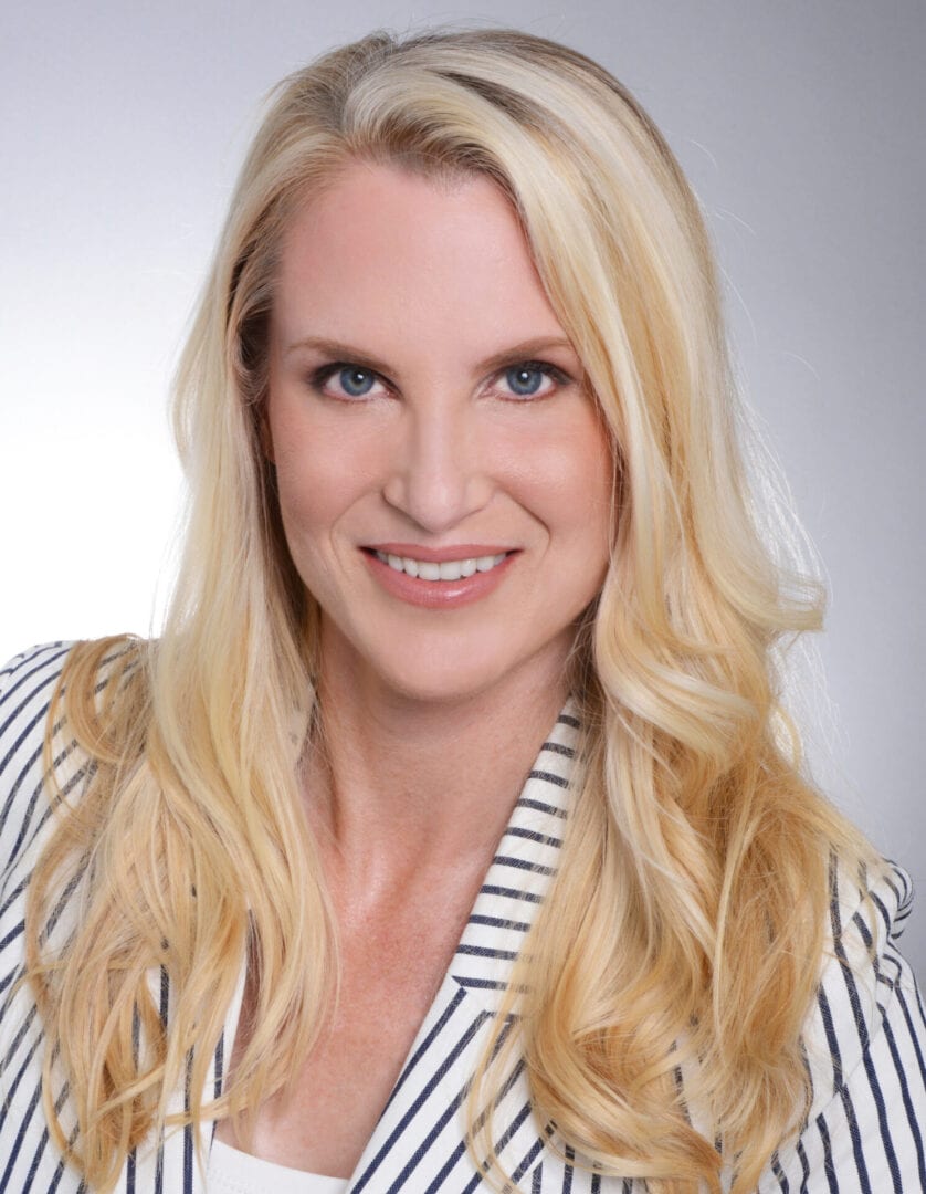 A woman with long blonde hair wearing a striped shirt.