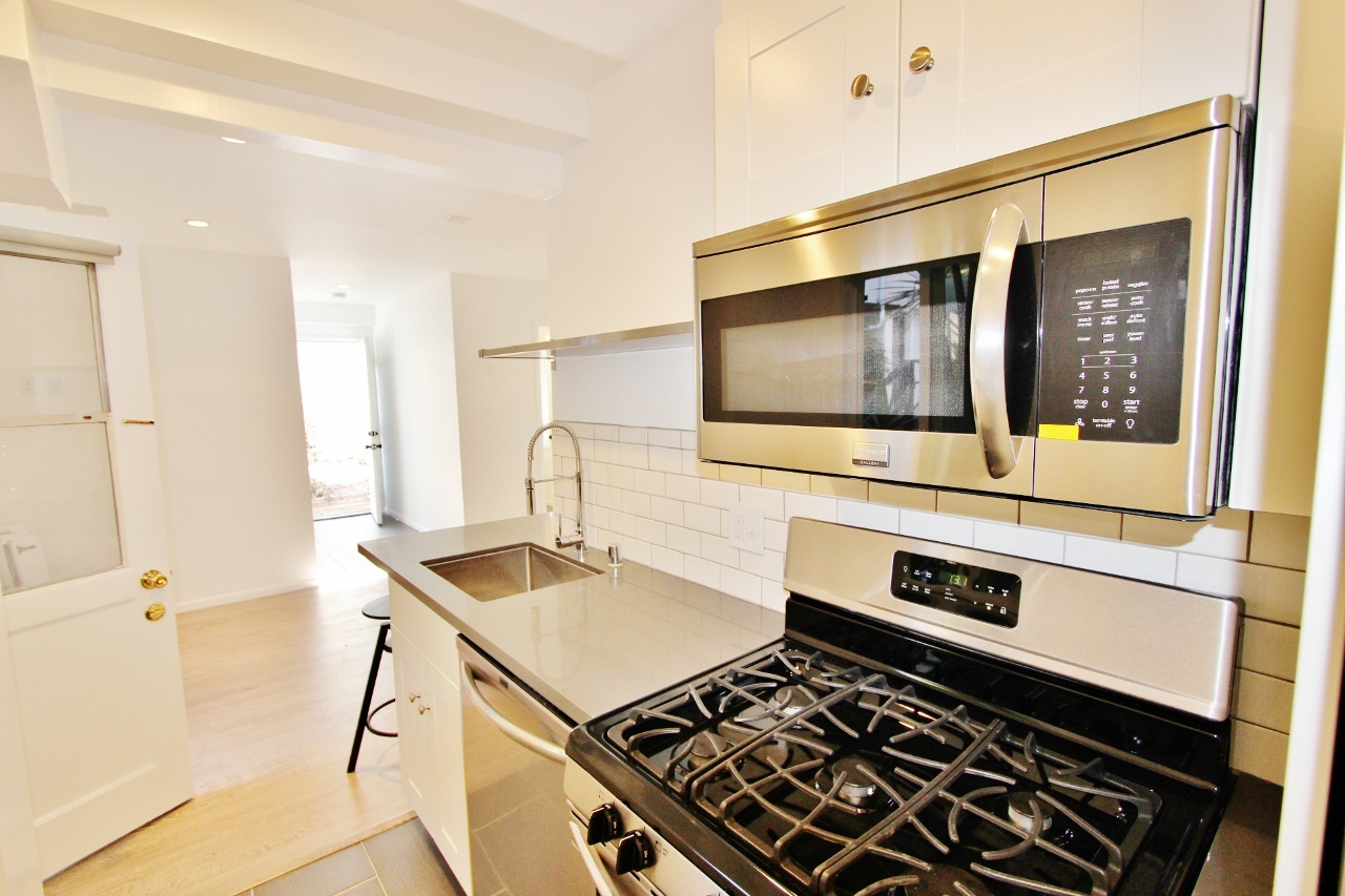 A kitchen with a stove and microwave in it