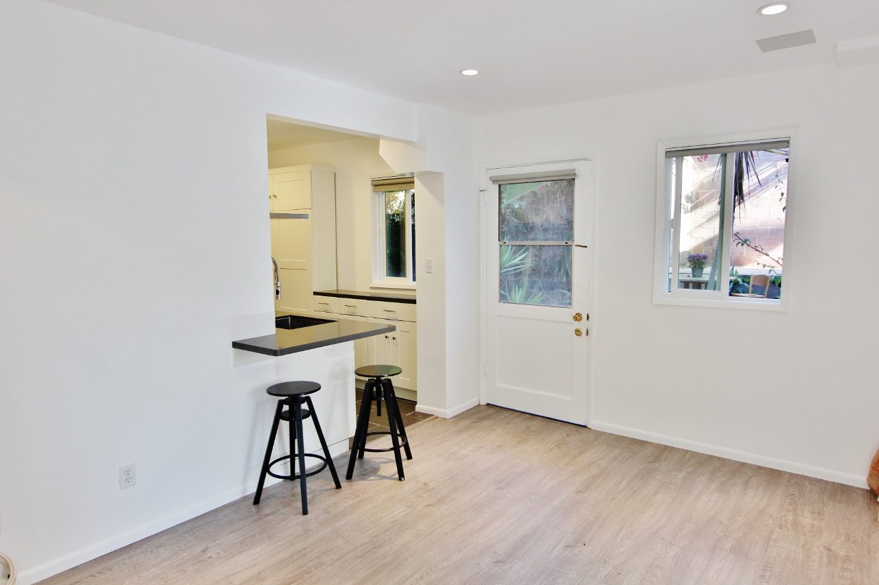 A room with a bar and two stools in it