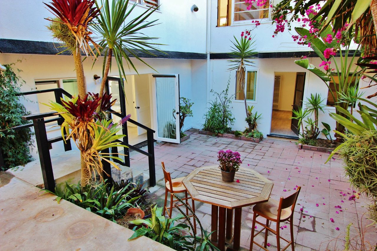 A table and chairs in the middle of an outdoor courtyard.