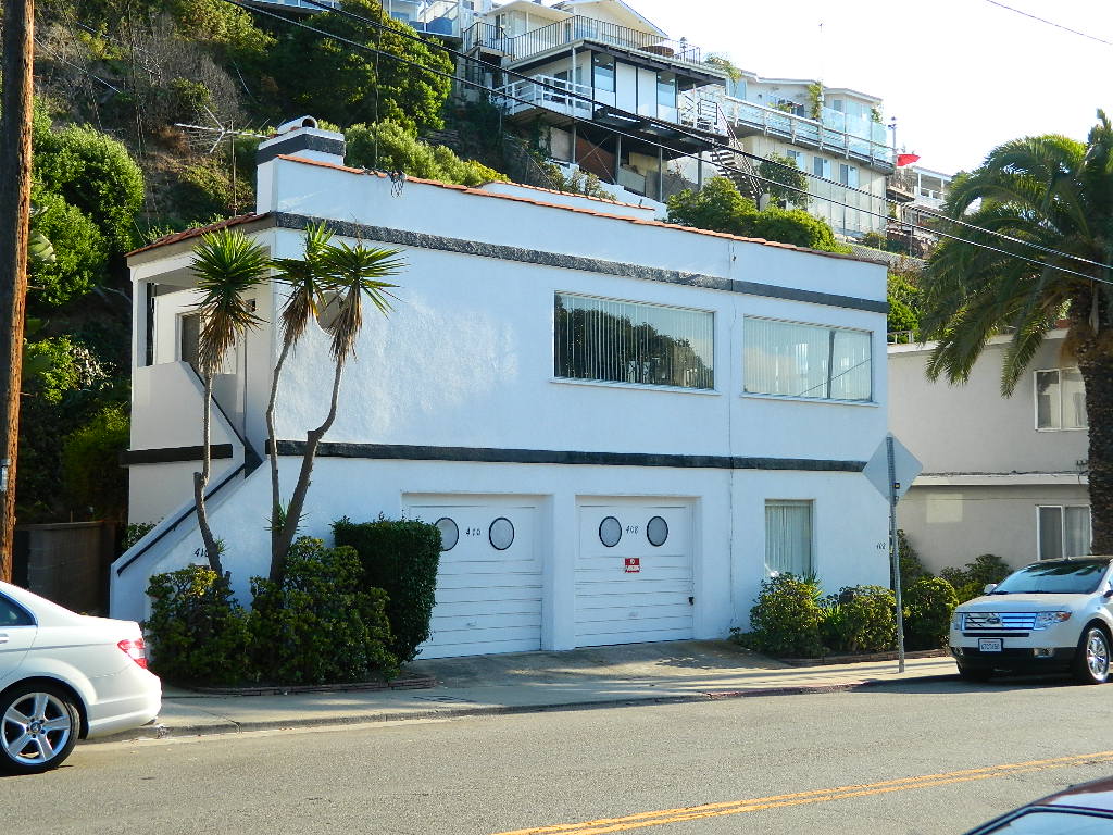 A white building with two doors and a garage.