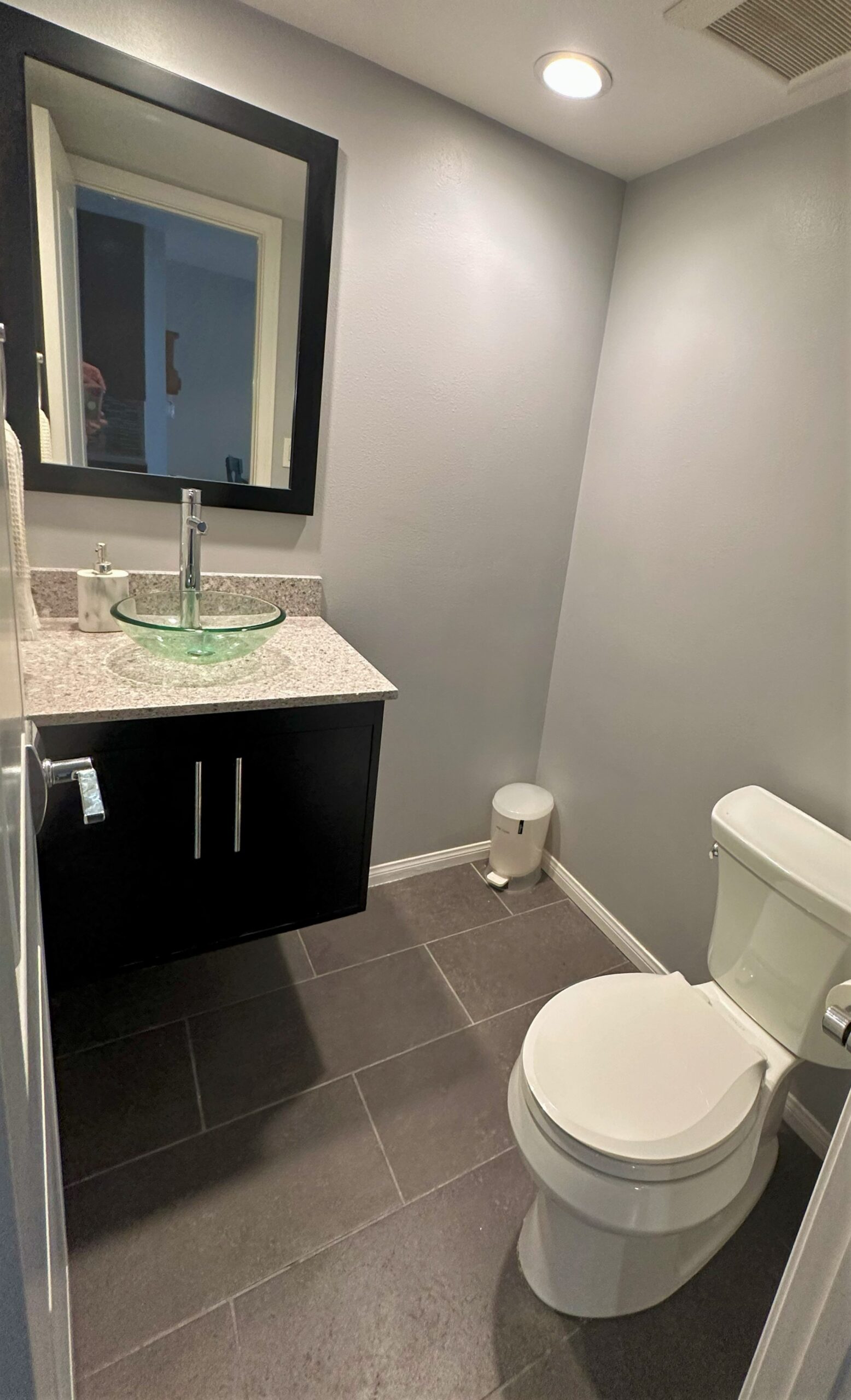 A bathroom with a sink, toilet and mirror.