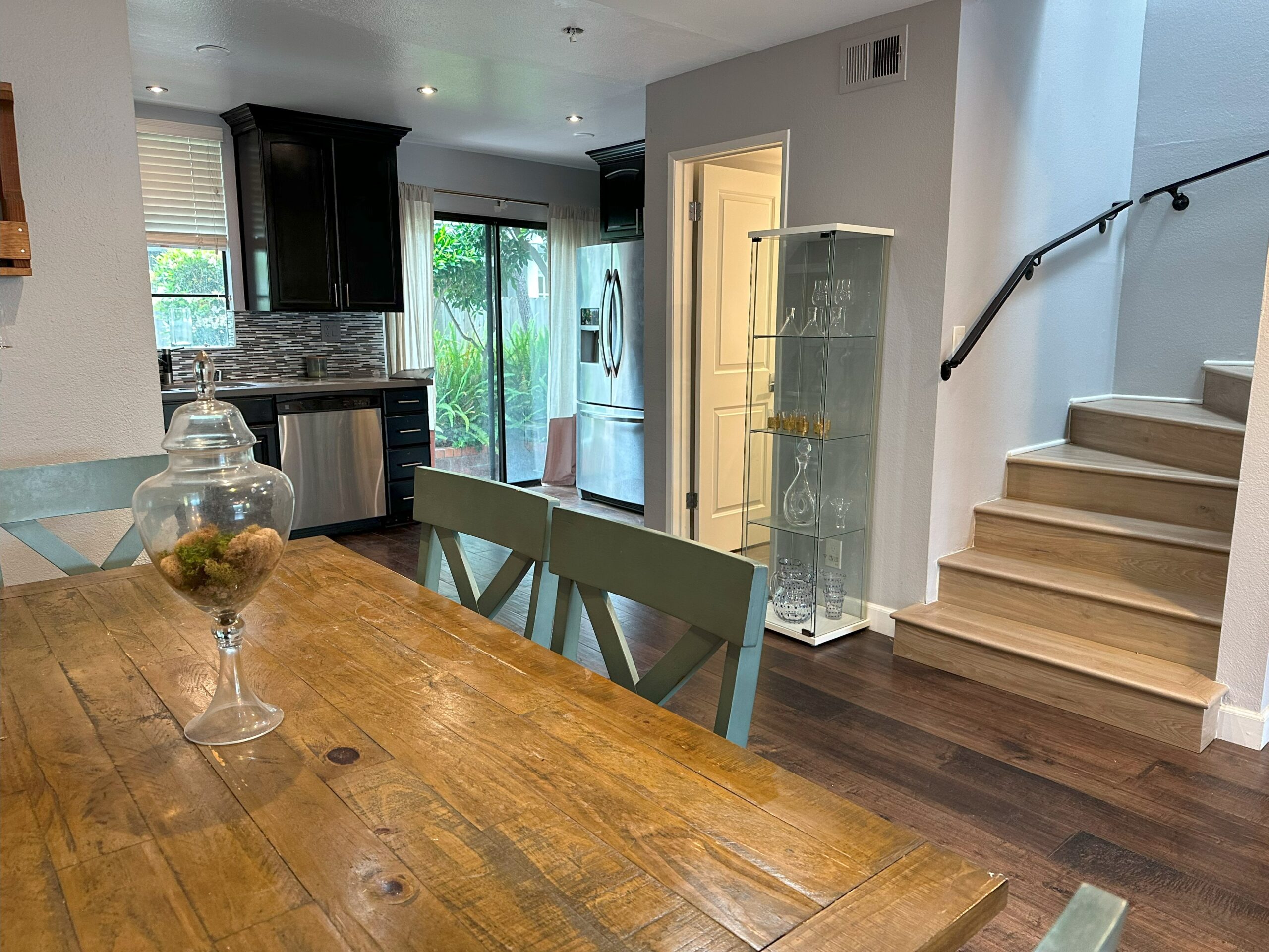 A dining room table with chairs and a glass case.