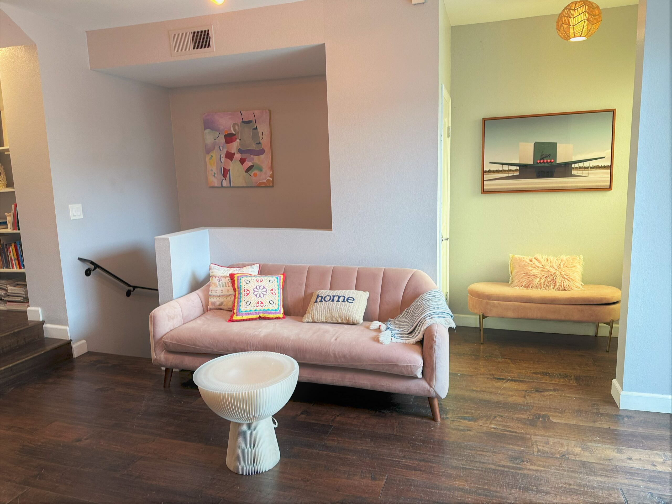 A living room with pink furniture and a toilet