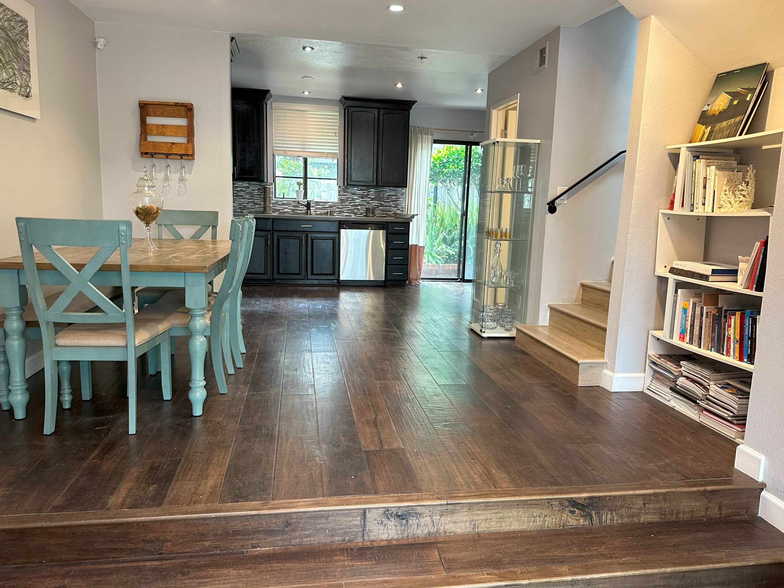 A kitchen and dining room with wooden floors