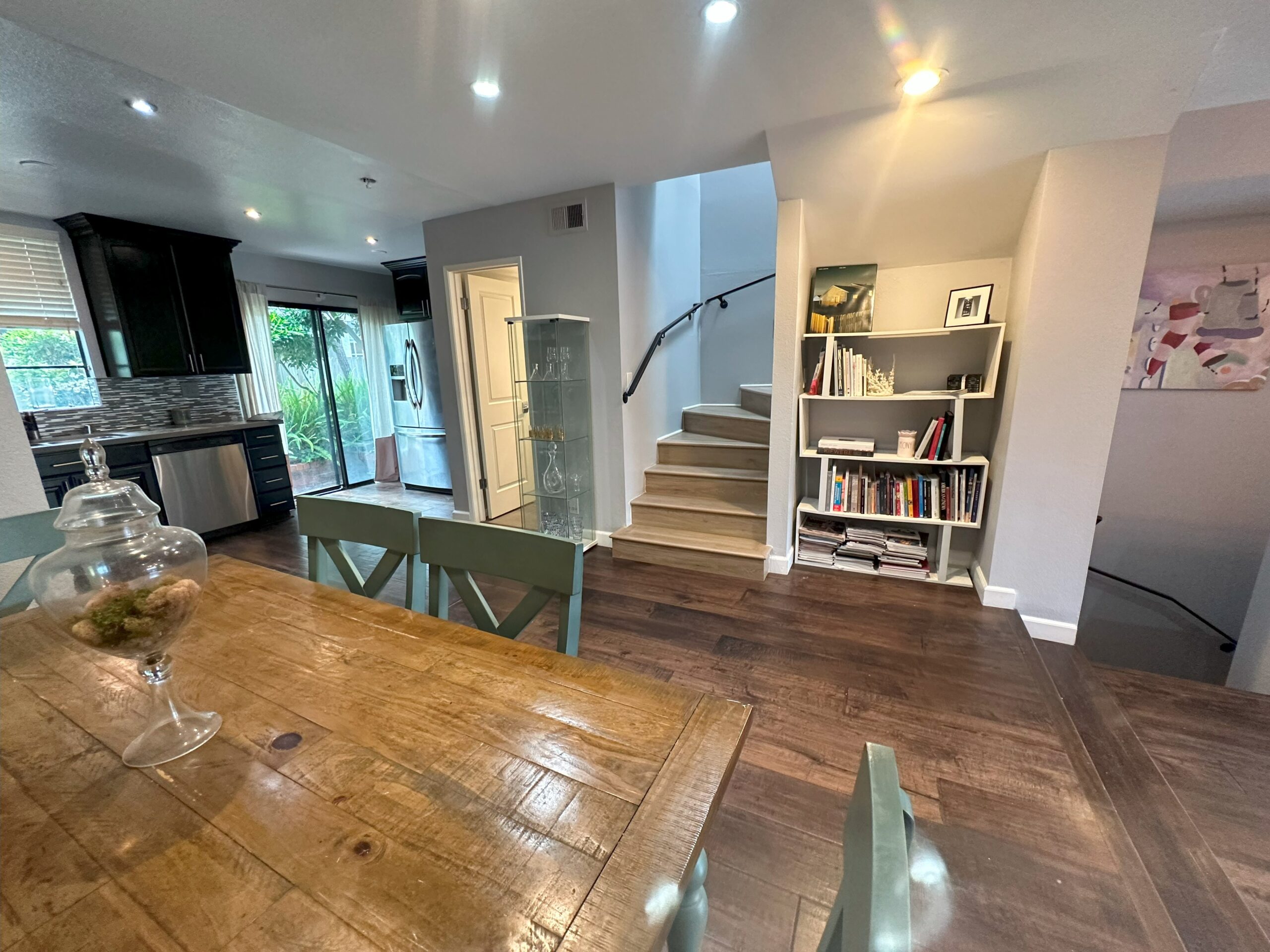 A room with wooden floors and stairs leading to the second floor.