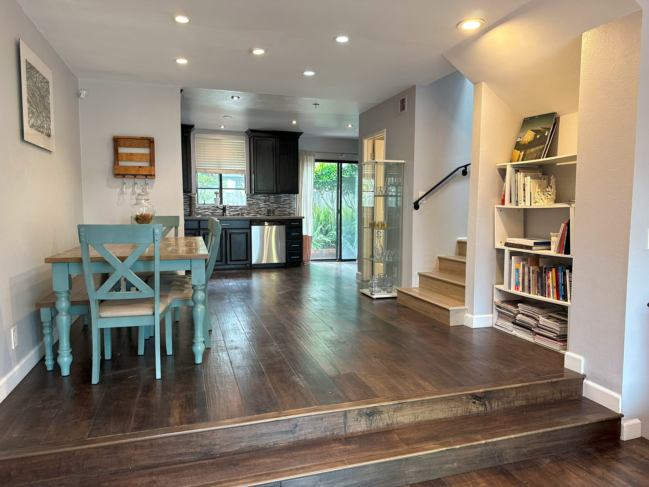 A living room with hard wood floors and blue chairs.