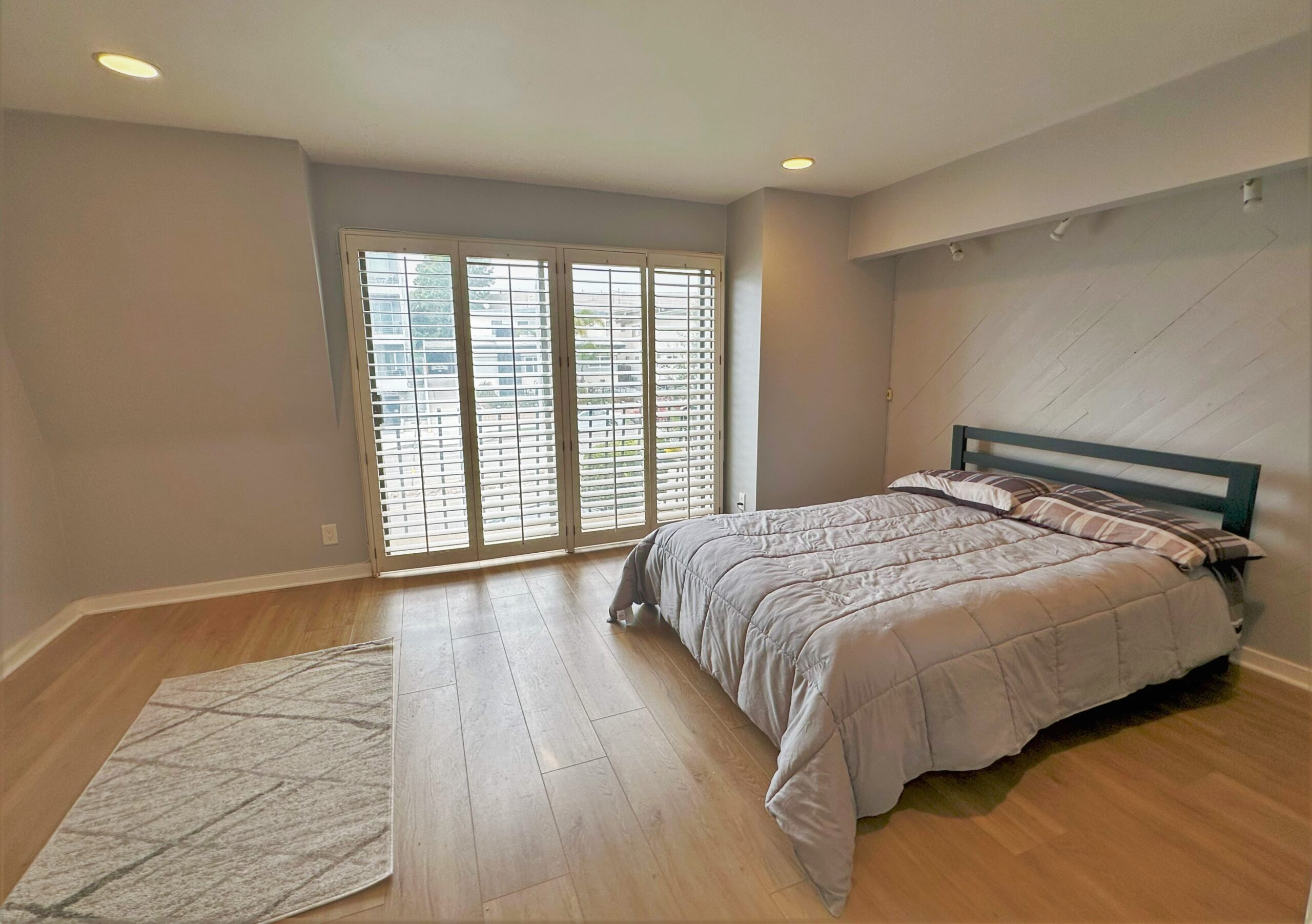 A bedroom with a large bed and sliding glass doors.