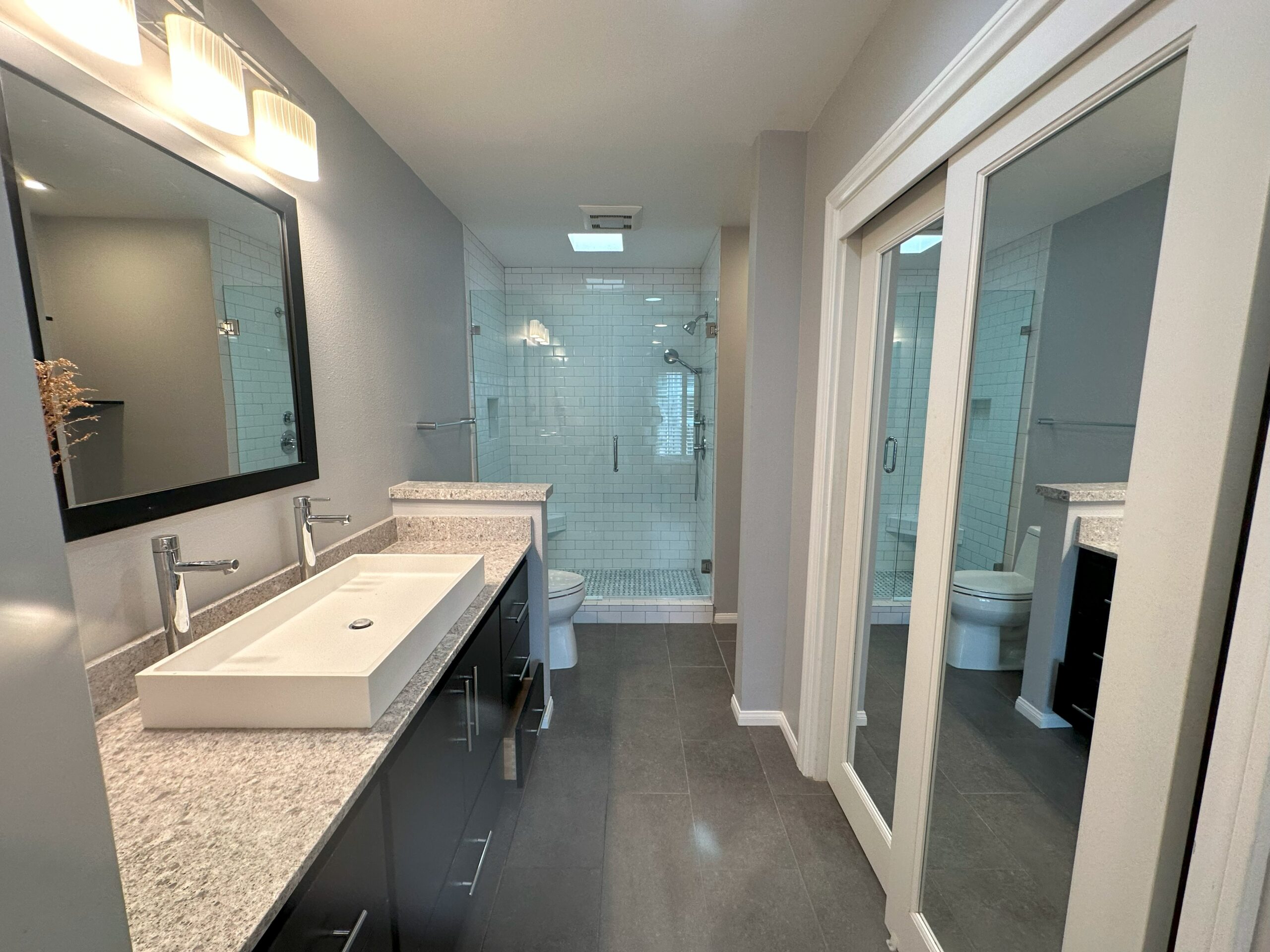 A bathroom with two sinks and a large mirror.