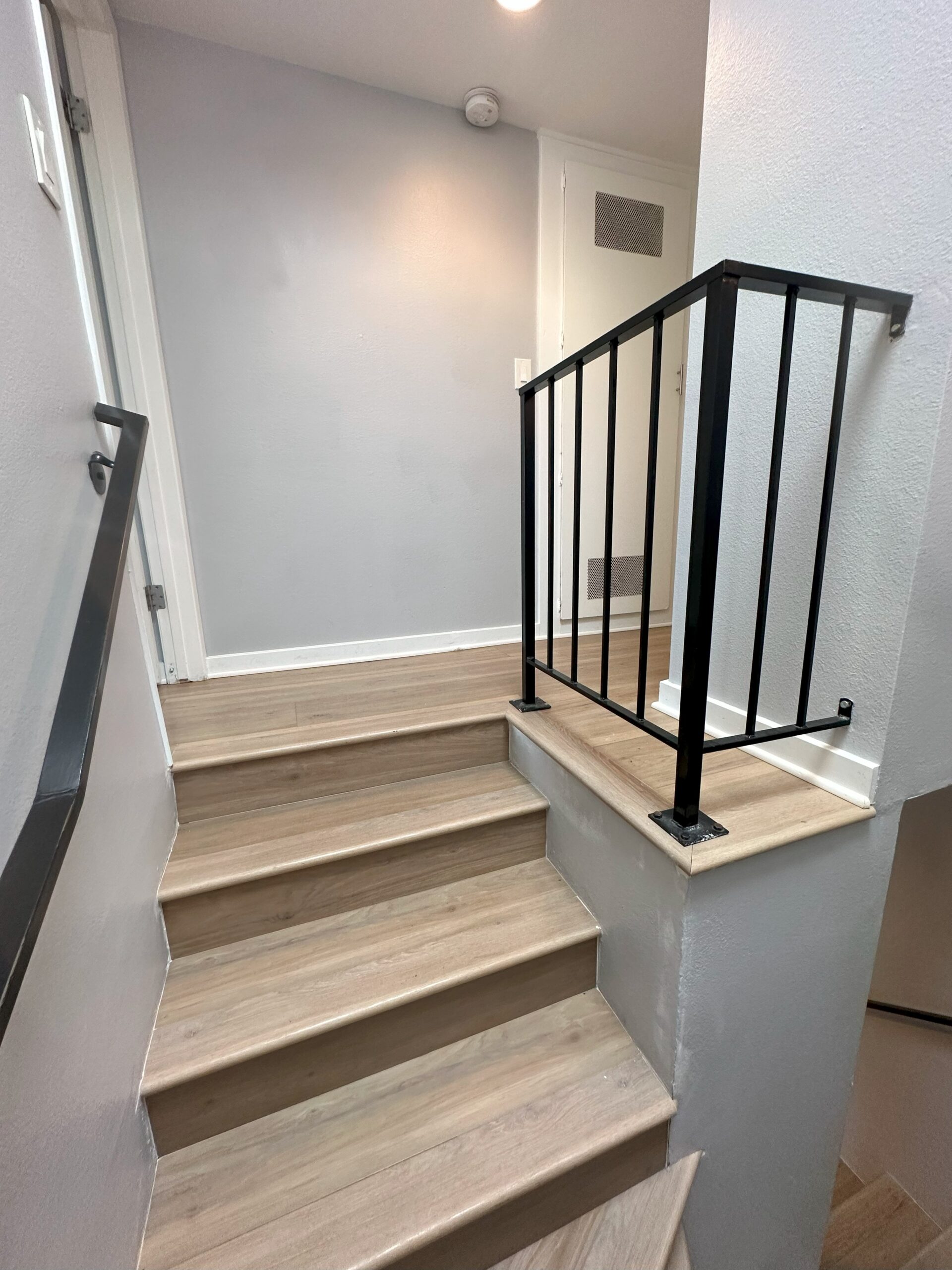 A staircase with wooden steps and metal railing.