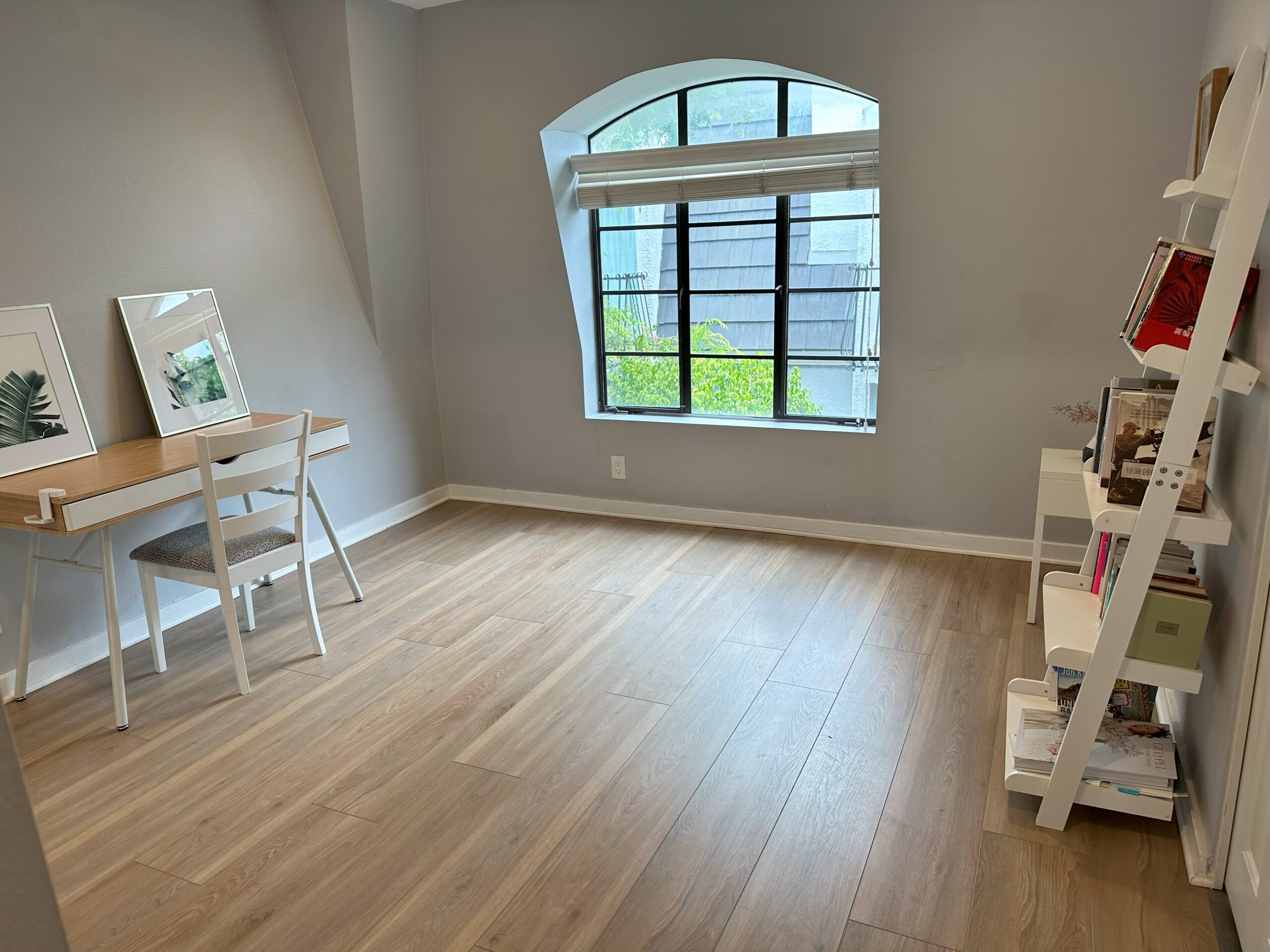 A room with hard wood floors and a desk.