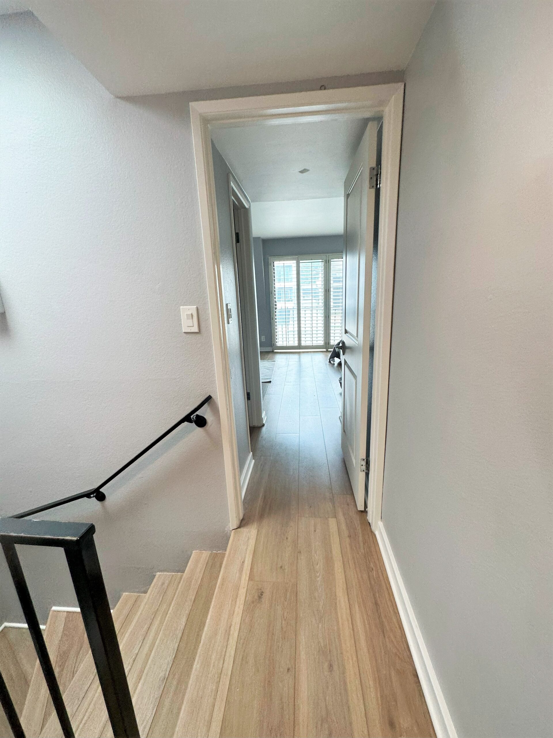 A hallway with stairs leading to the second floor.