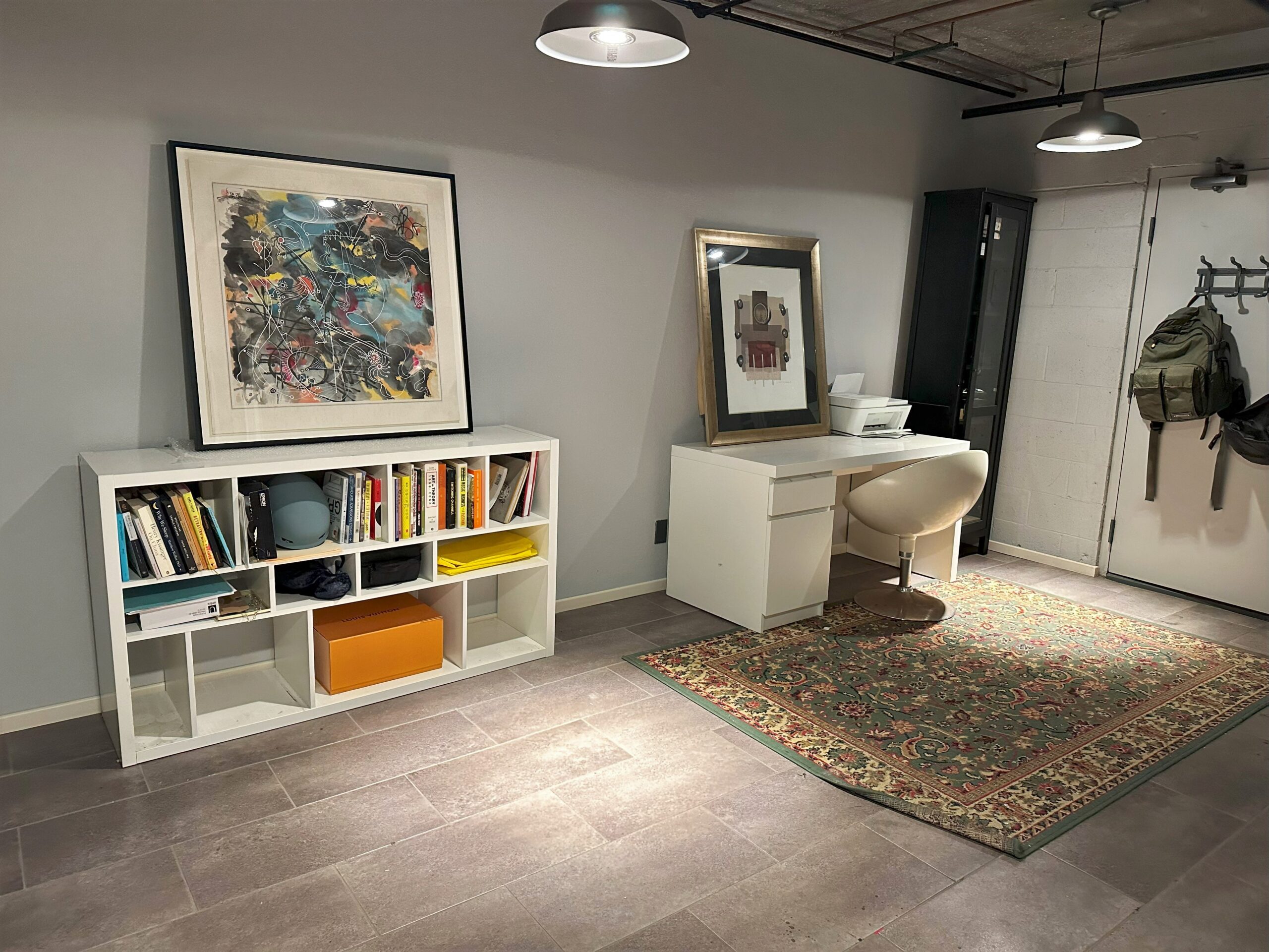 A room with a desk, chair and bookshelf.