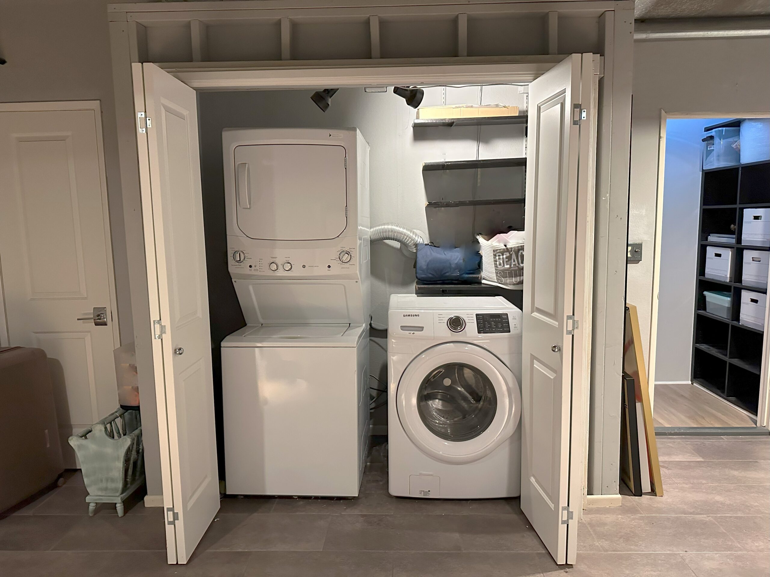 A washer and dryer in the middle of an unfinished room.