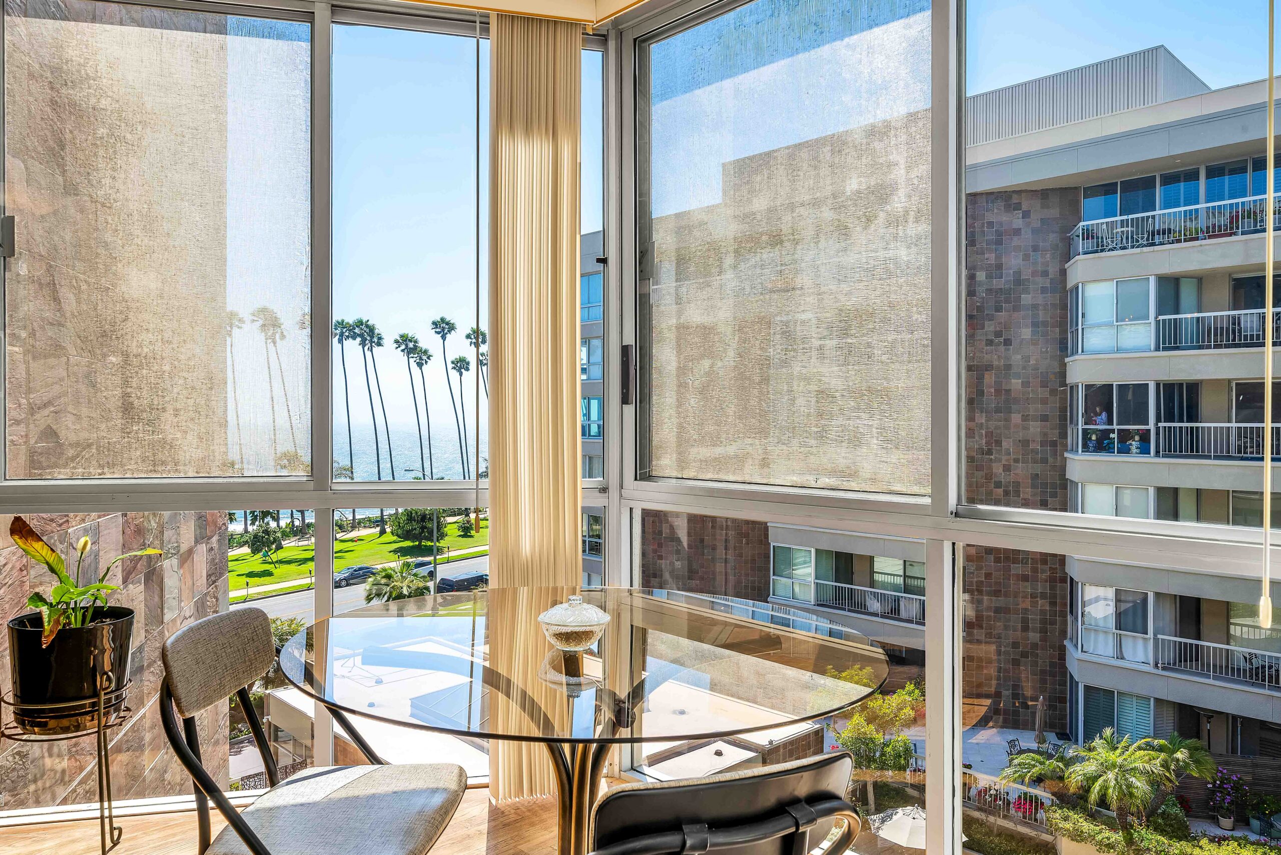 A glass table with chairs and a large window.