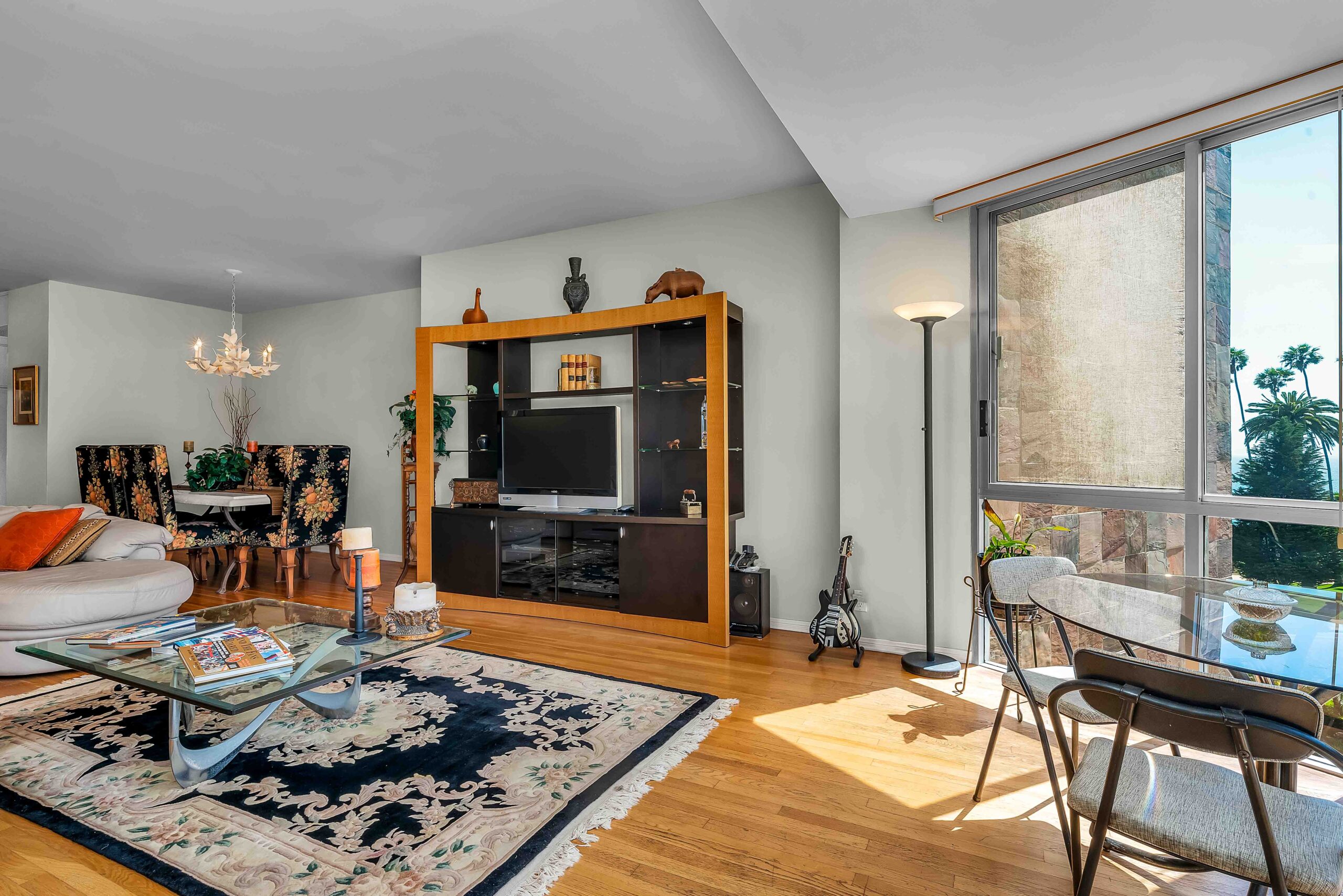 A living room with a large window and wooden floors