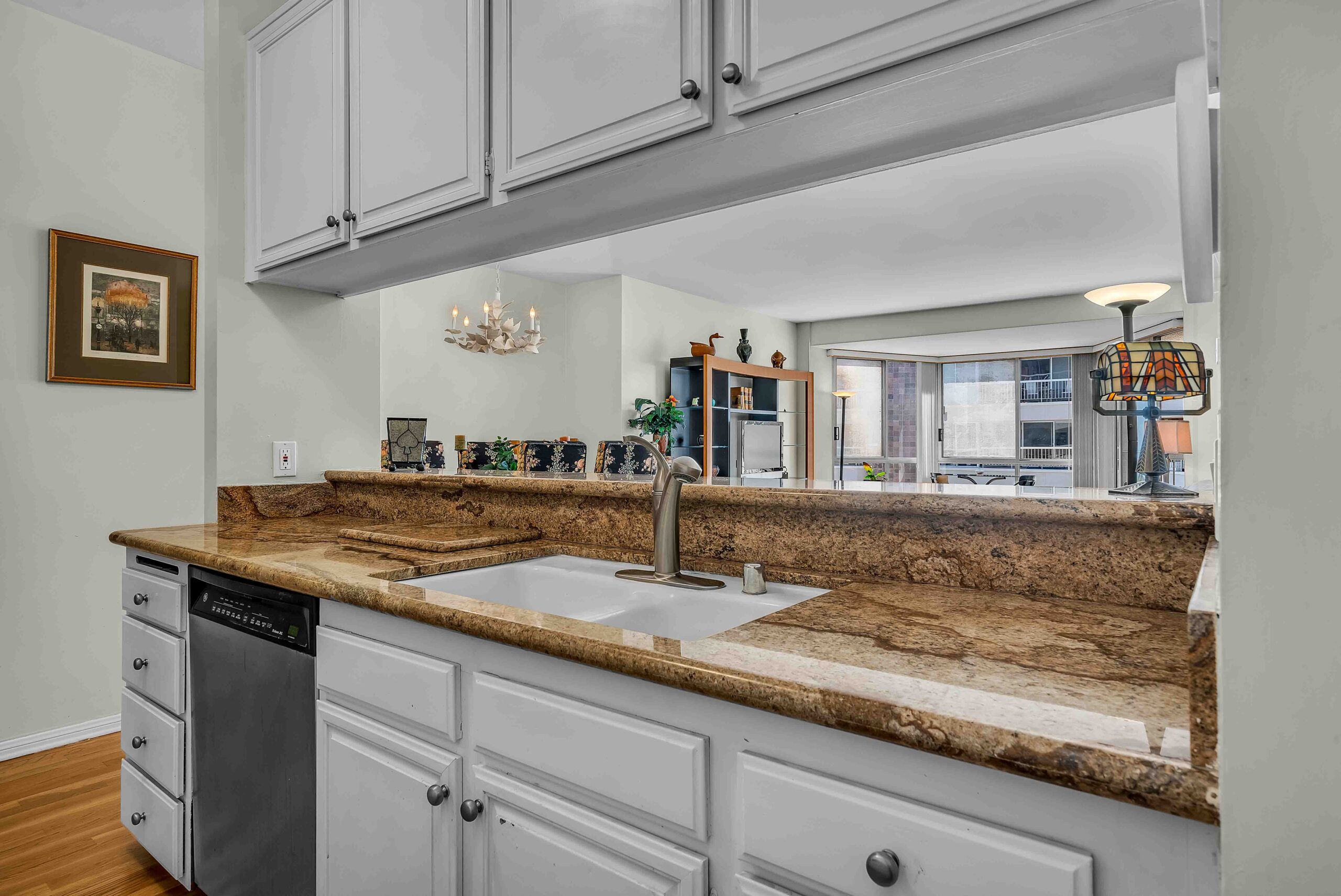 A kitchen with white cabinets and brown counter tops.