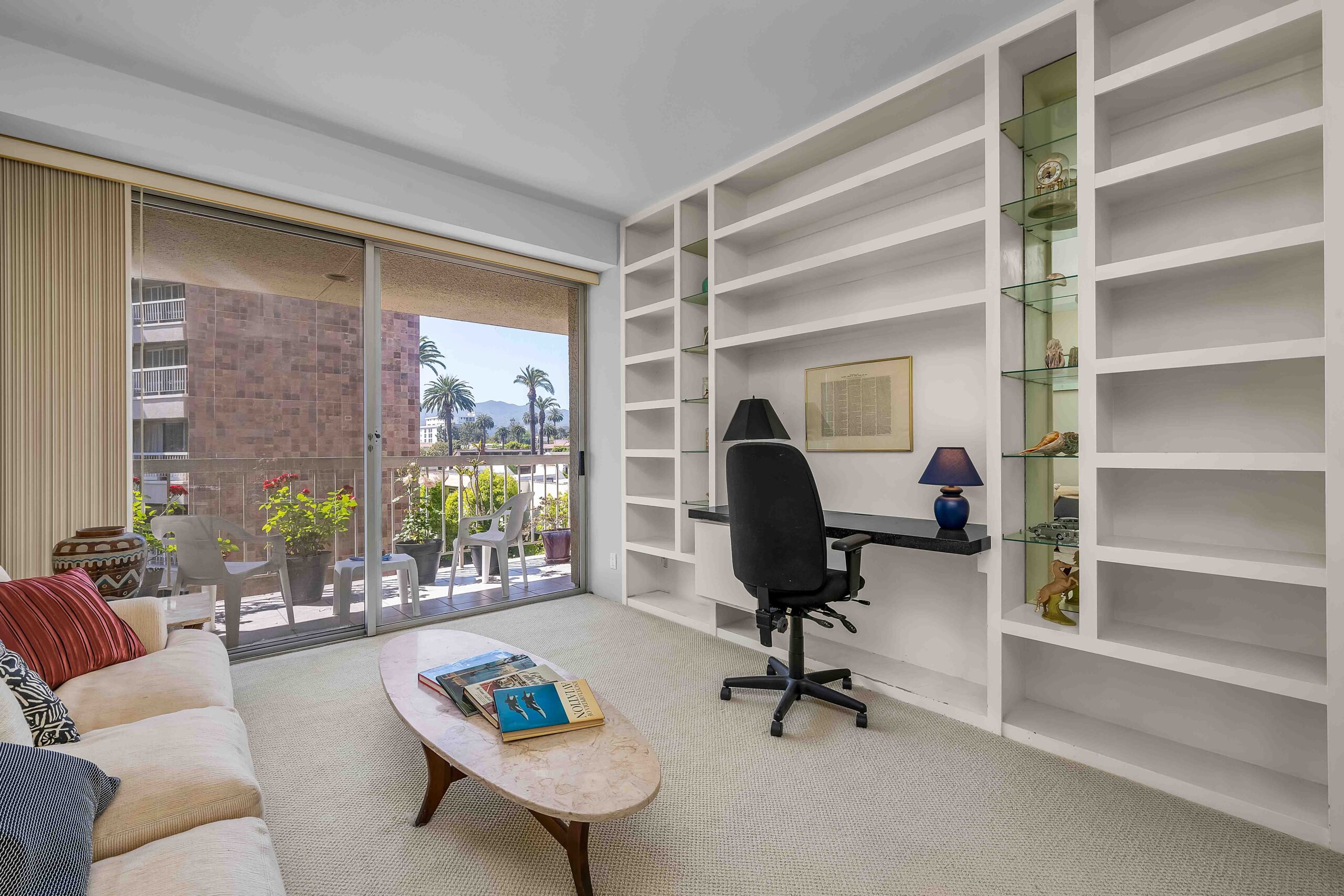 A living room with a desk and chair in it