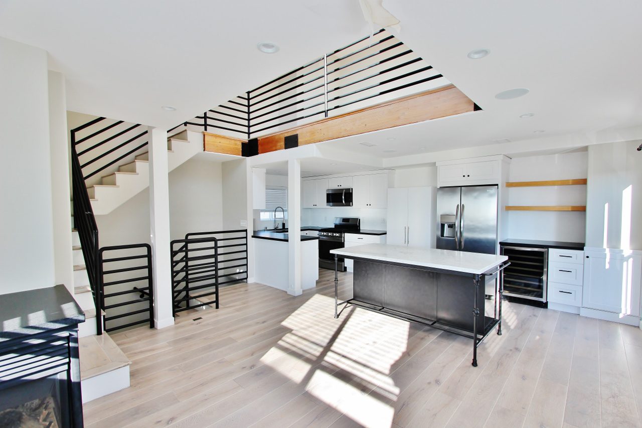 A kitchen with stairs and a counter in it