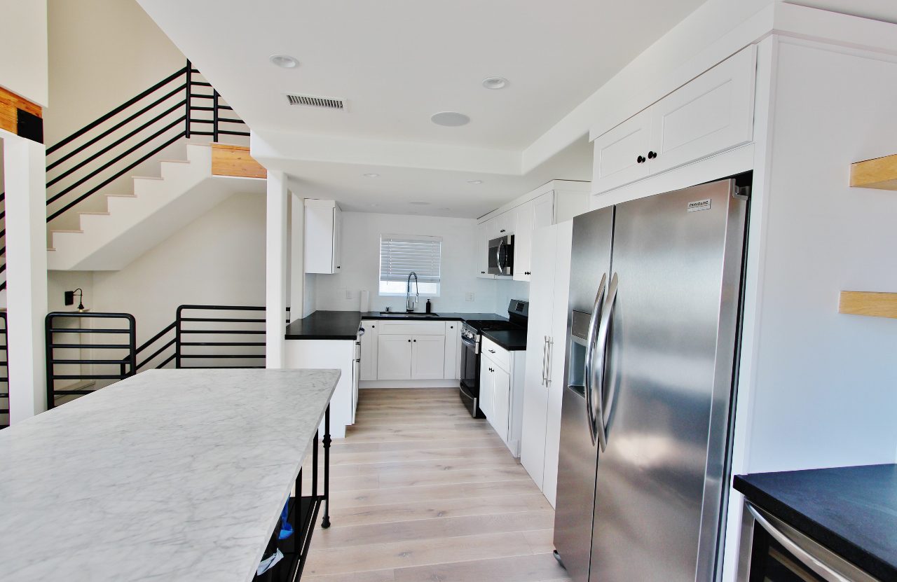 A kitchen with stainless steel appliances and white cabinets.