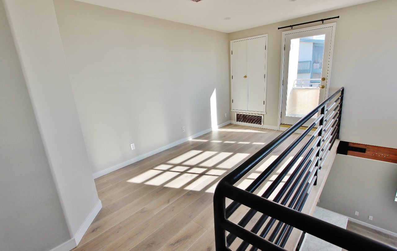 A room with a black railing and white walls.