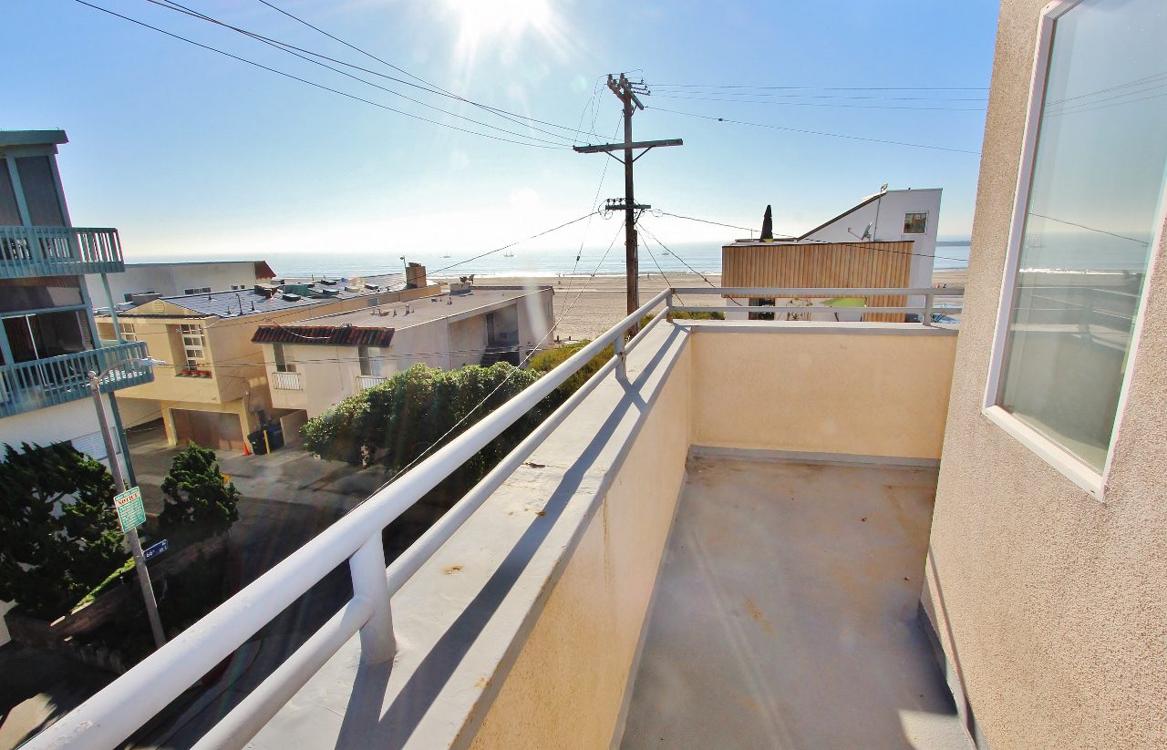 A balcony with a view of the ocean and a telephone pole.