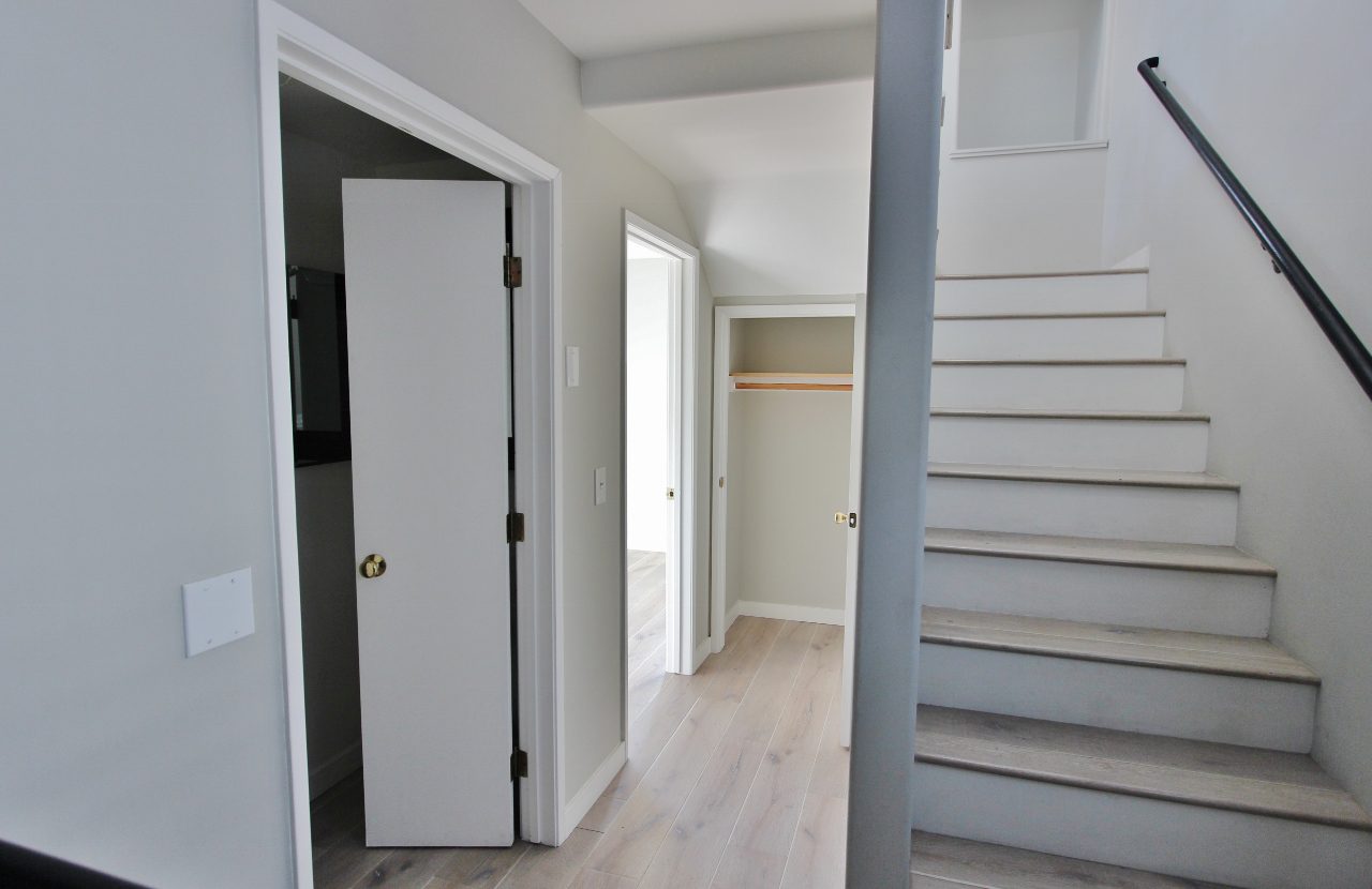 A hallway with stairs leading to the second floor.