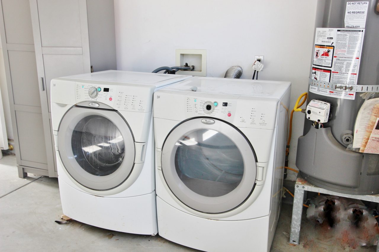 A couple of white washer and dryer in a room.