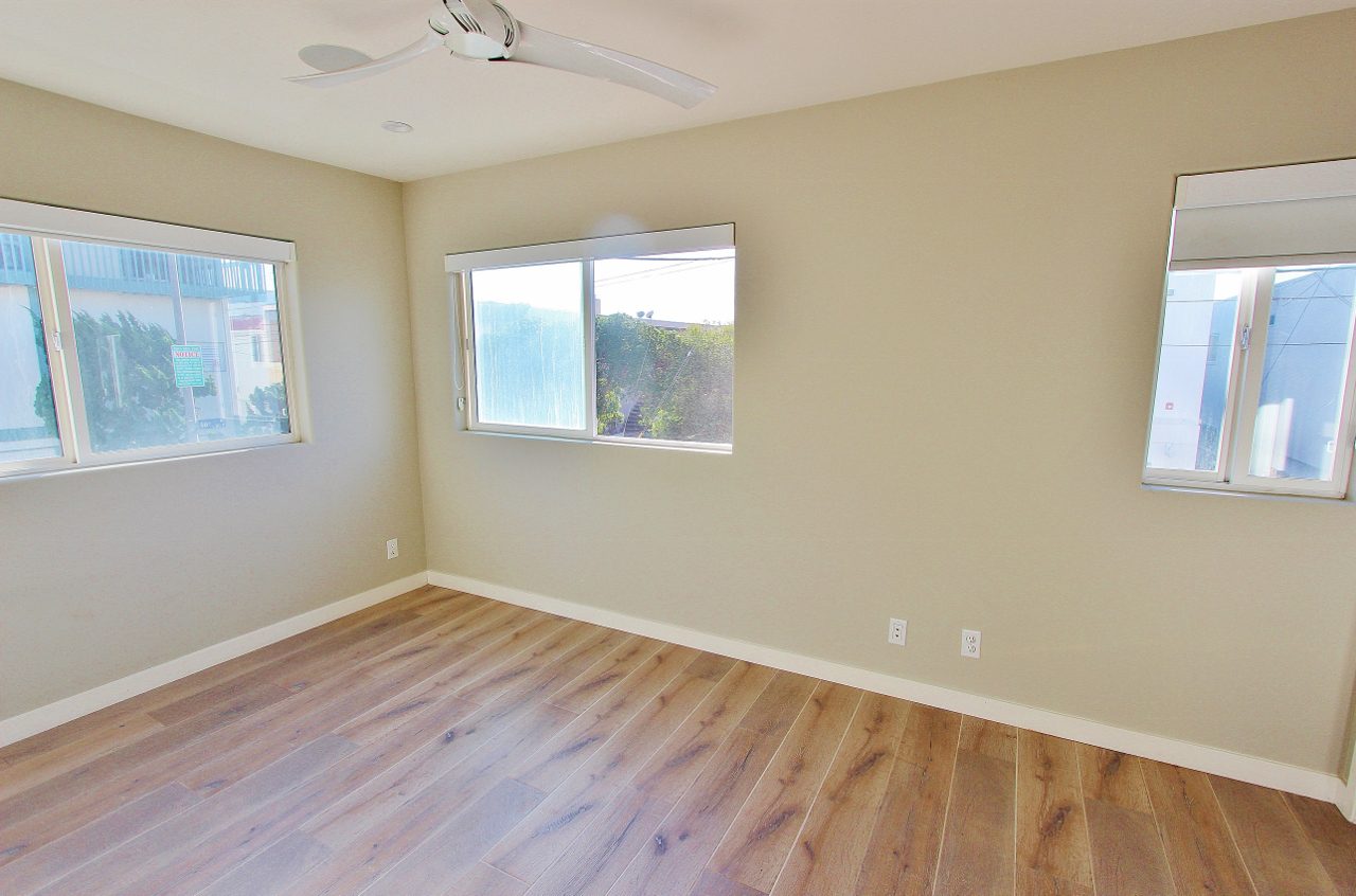 A room with hard wood floors and a ceiling fan.