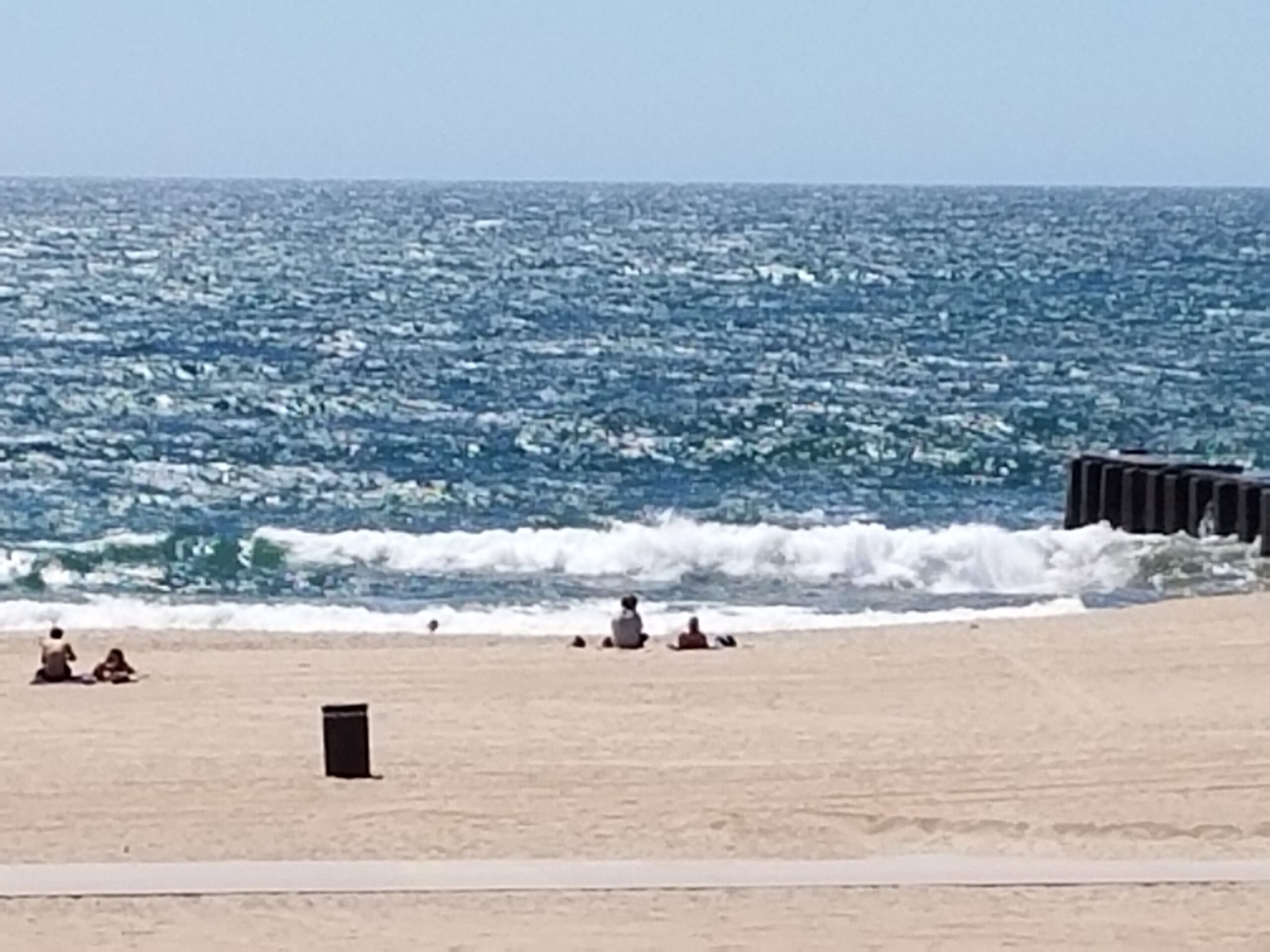 A person sitting on the beach near the ocean.