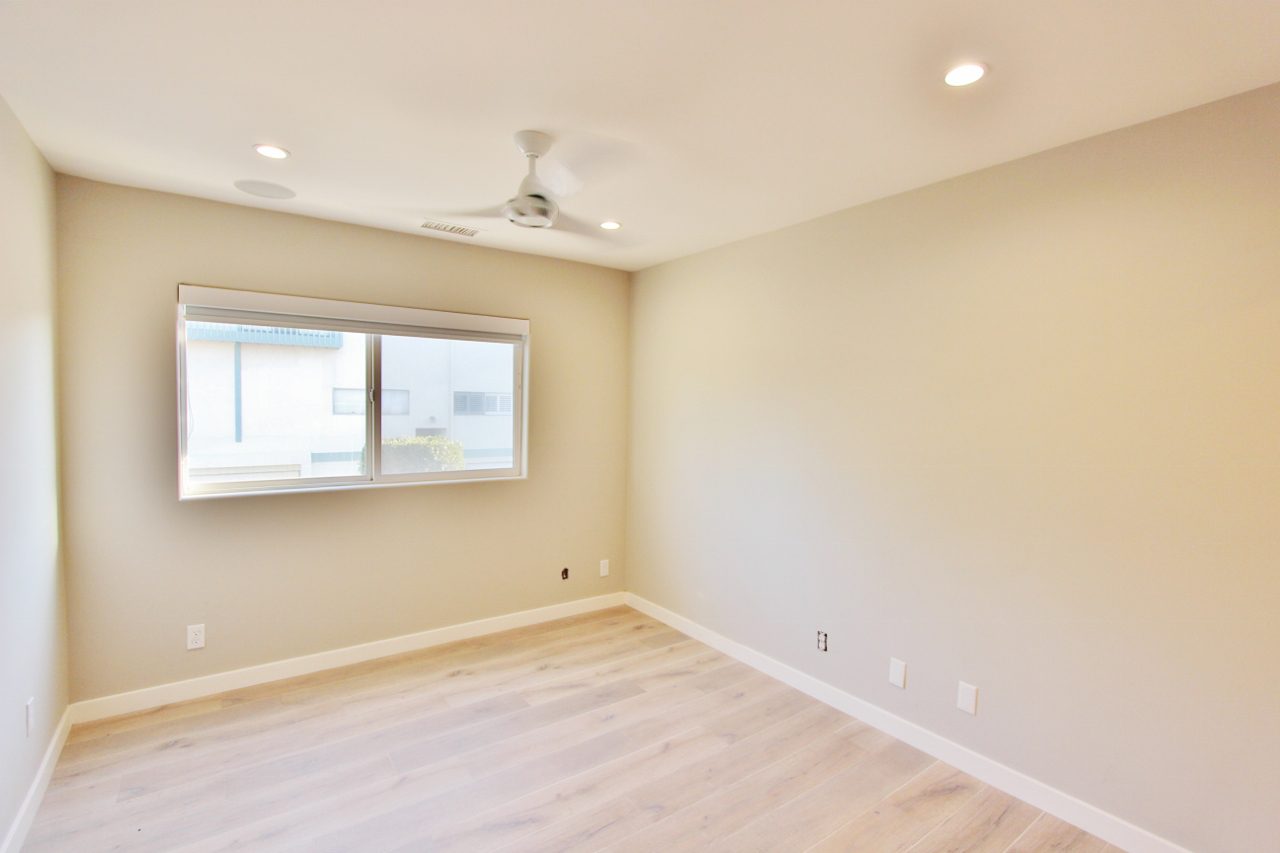 A room with a ceiling fan and a window.