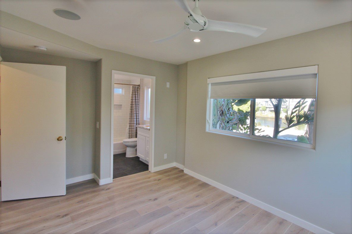 A room with a window and a ceiling fan.