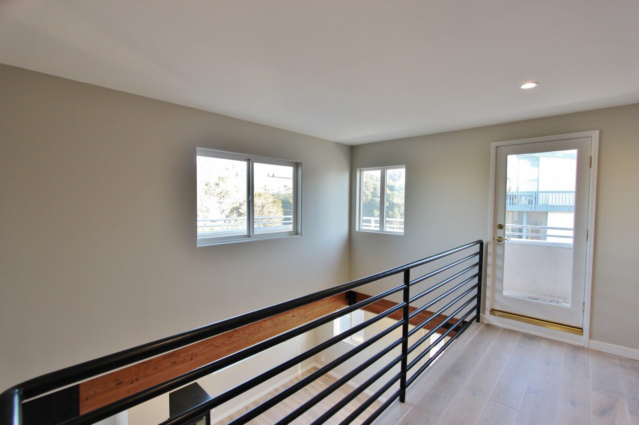 A room with a railing and two windows.