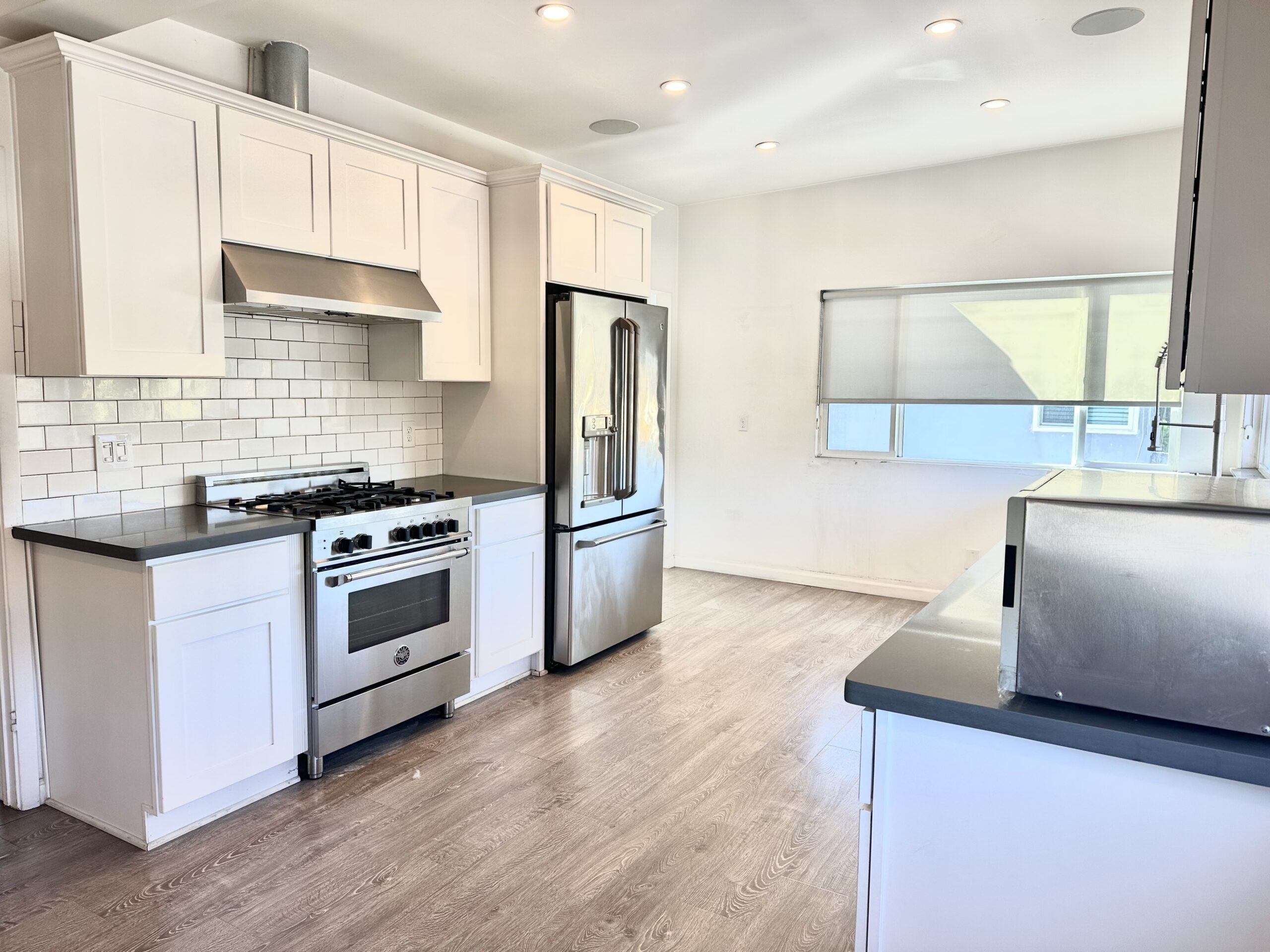 A kitchen with white cabinets and stainless steel appliances.