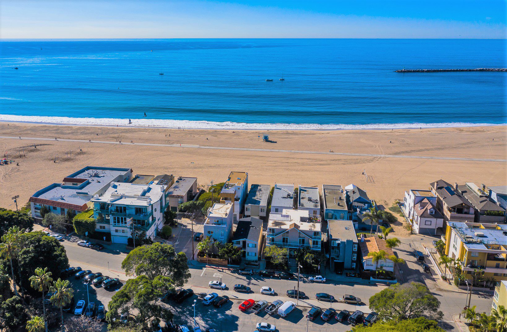 A beach with cars parked on the side of it.