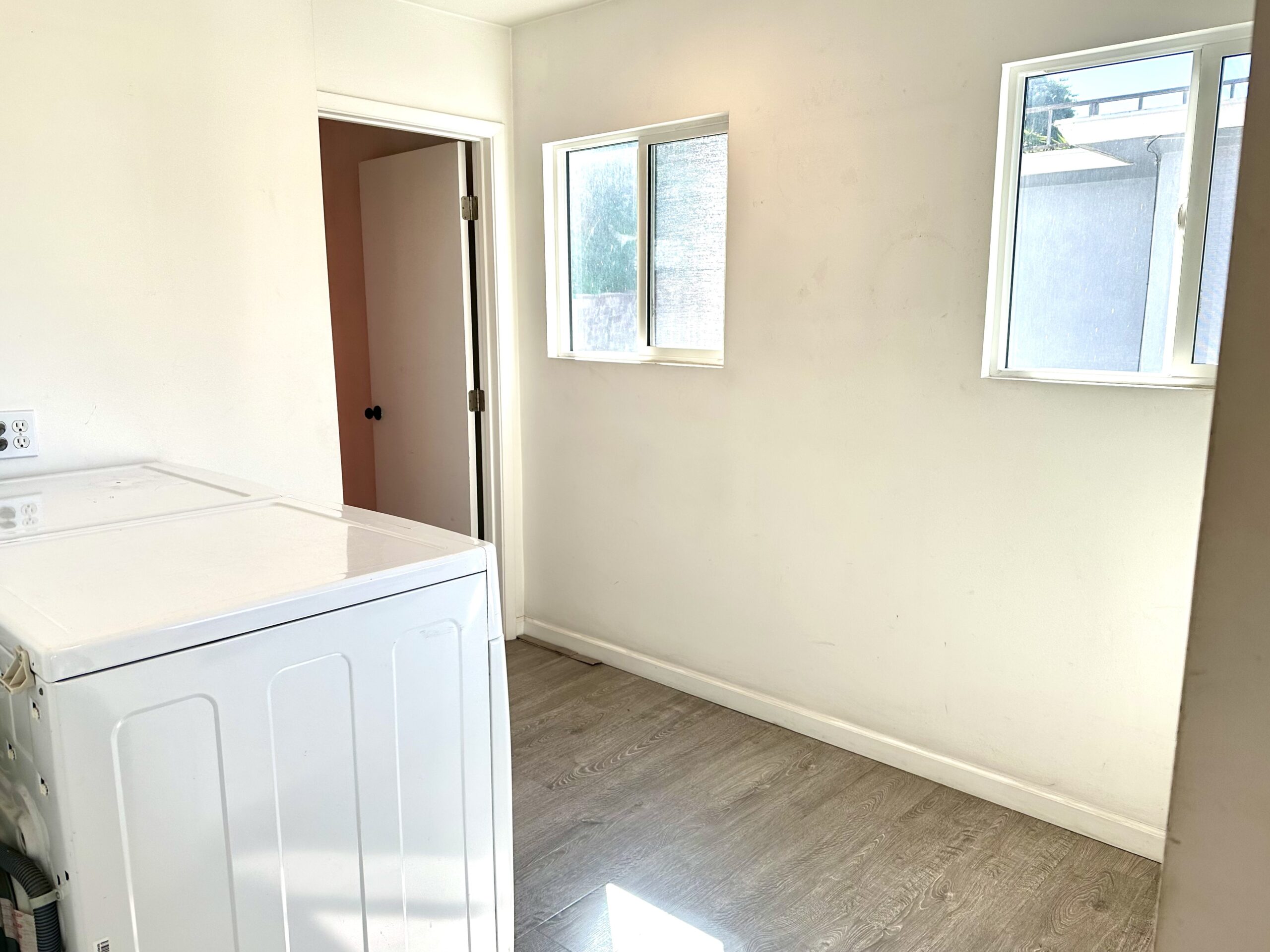 A room with white walls and wooden floors.