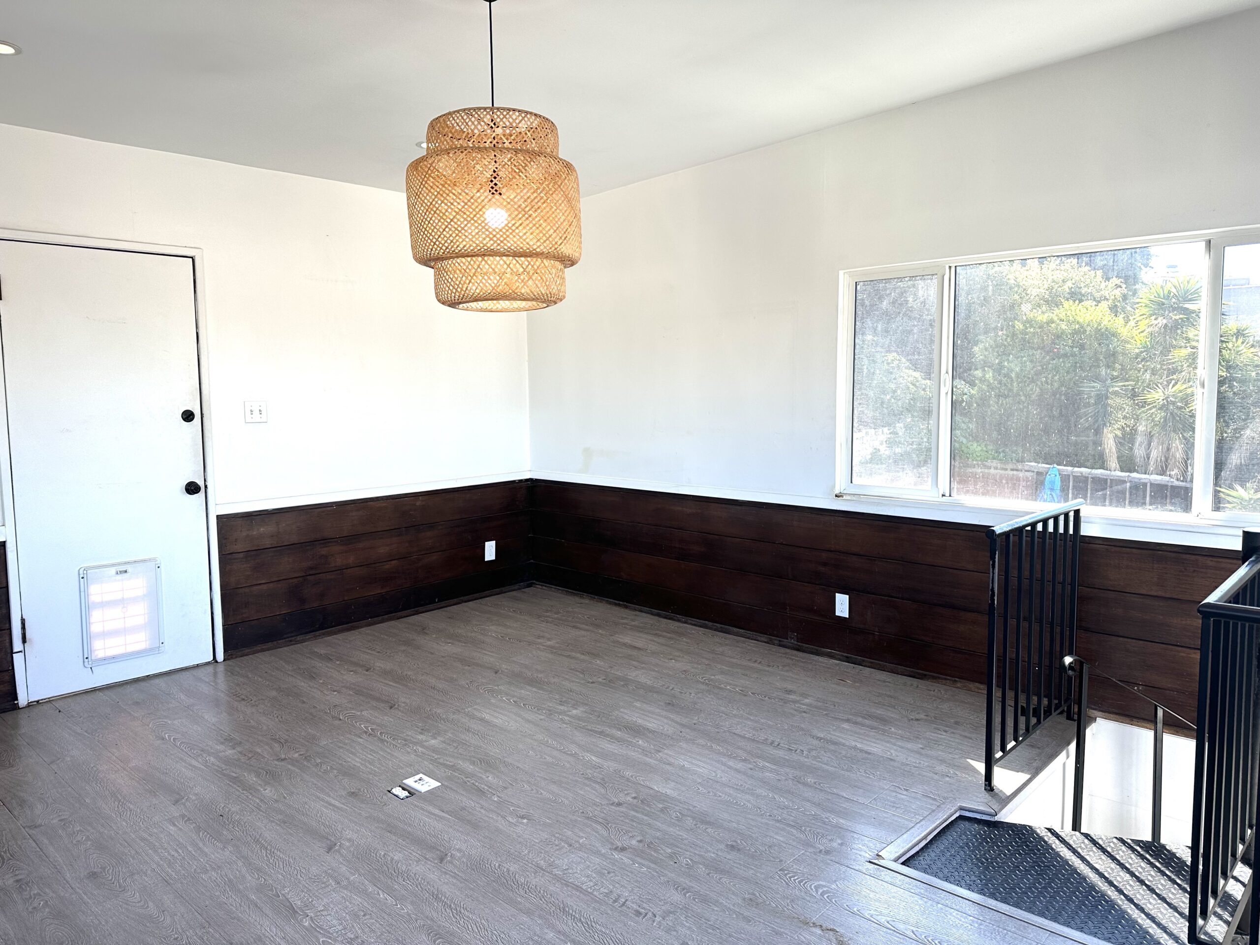 A room with wood paneling and a black door.