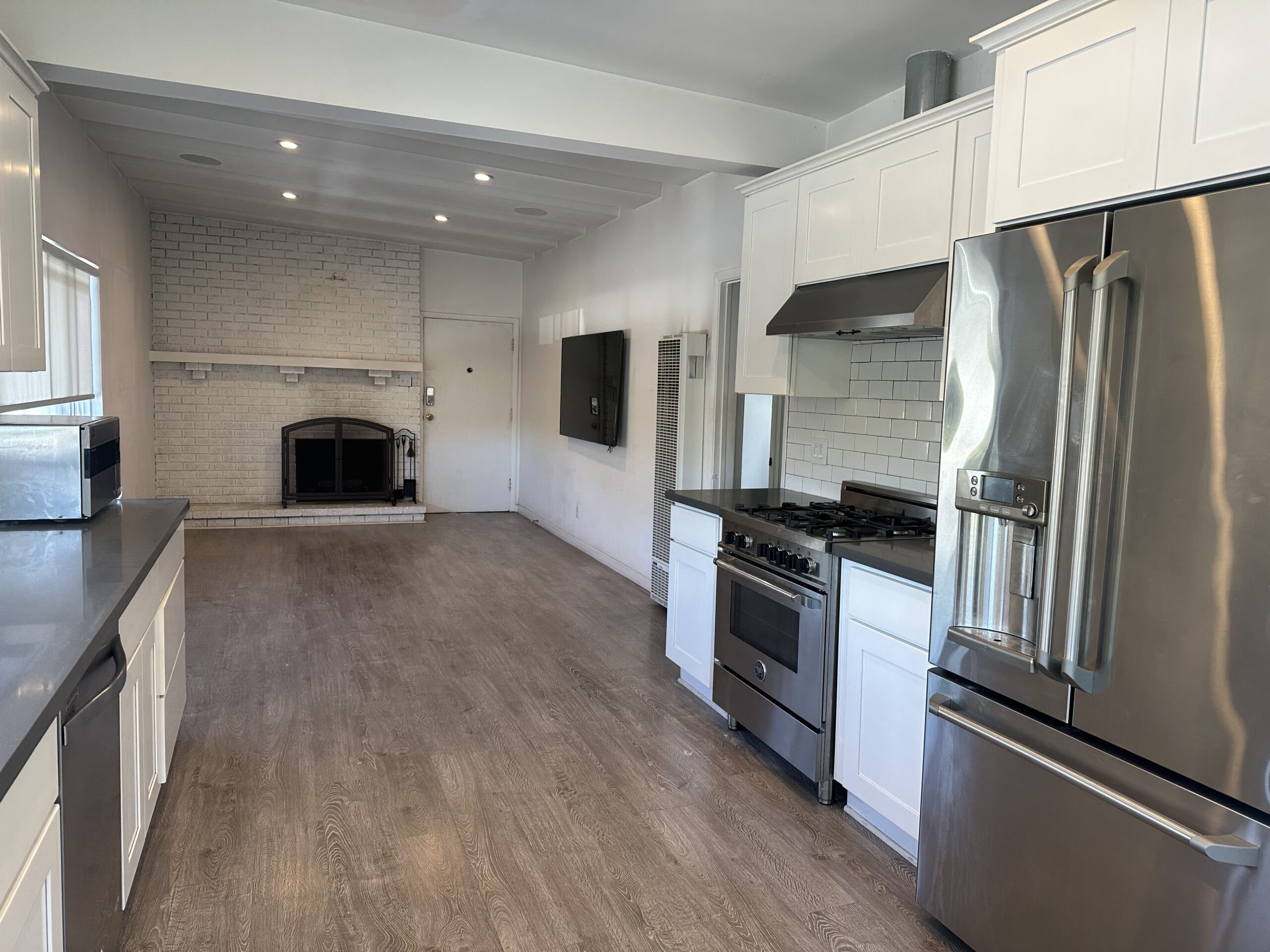 A kitchen with stainless steel appliances and white cabinets.